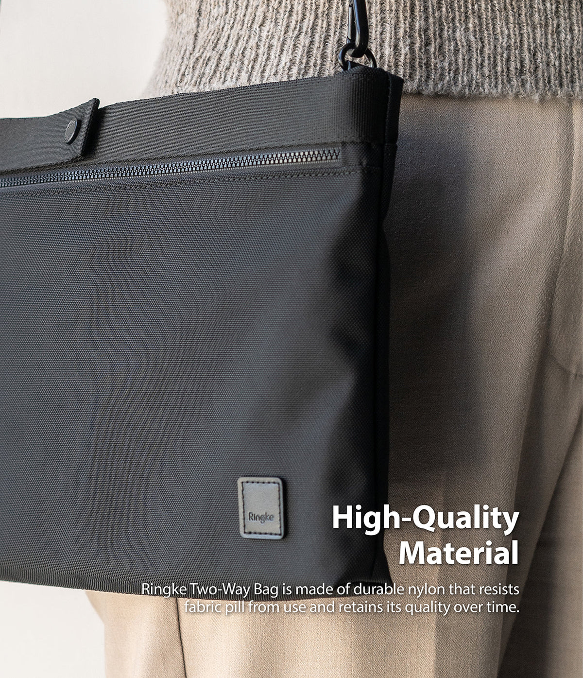 2-Way Bag - Close-up of a black nylon crossbody bag with a zipper, snap button, and Ringke logo patch on a person.