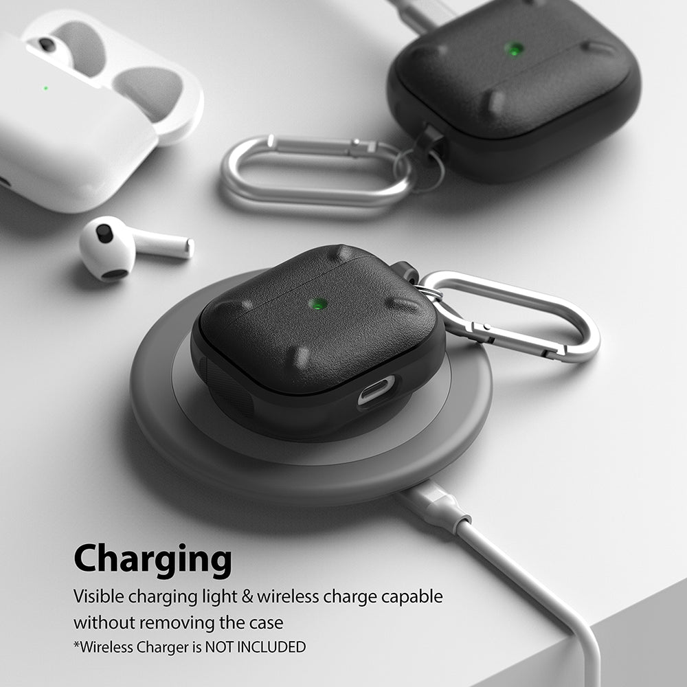 AirPods 3 Case | Onyx - Black textured AirPods case with a silver carabiner charging wirelessly on a grey pad.