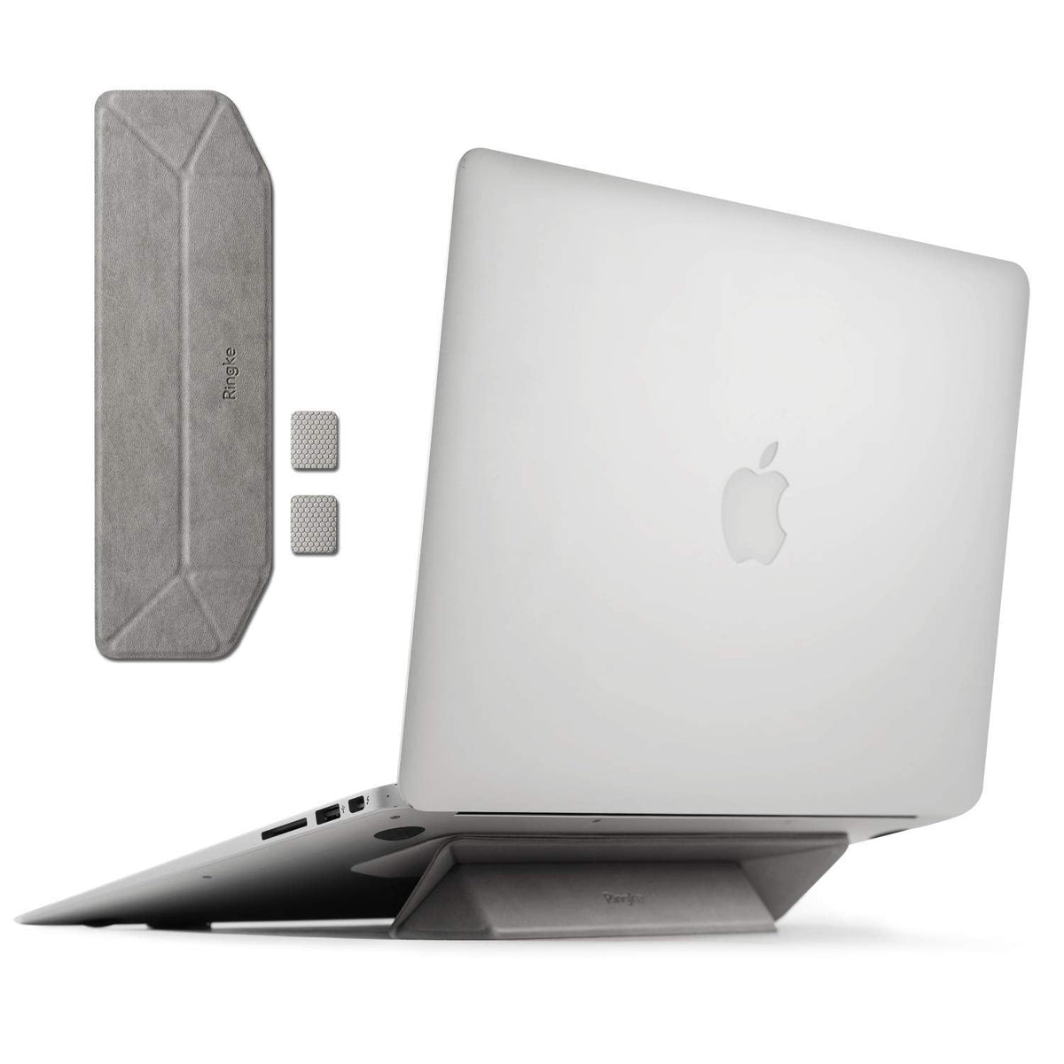 Laptop Stand - A grey foldable adhesive laptop stand attached to the base of a silver laptop, with extra pads shown.