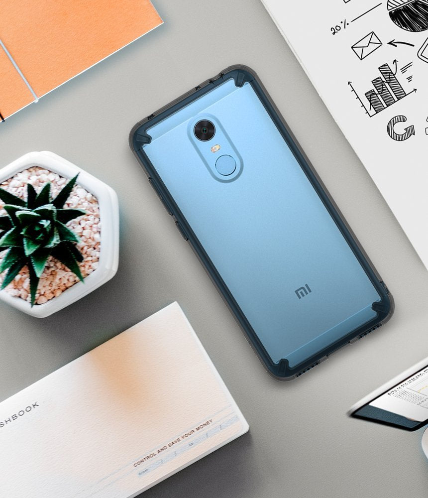 Redmi Note 5 / 5 Plus | Fusion - Light blue smartphone in a protective case on a desk with a succulent and business notes.