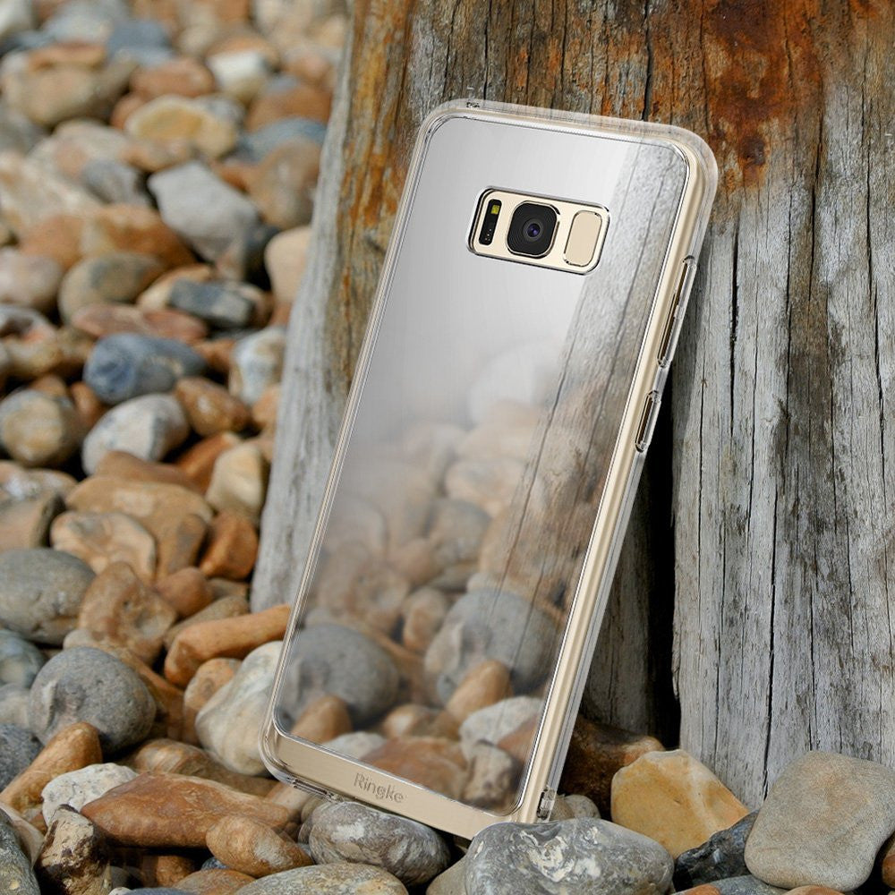 Galaxy S8 Plus Case | Mirror - Reflective mirror-finish phone case leaning against a wooden post on a pebble beach.