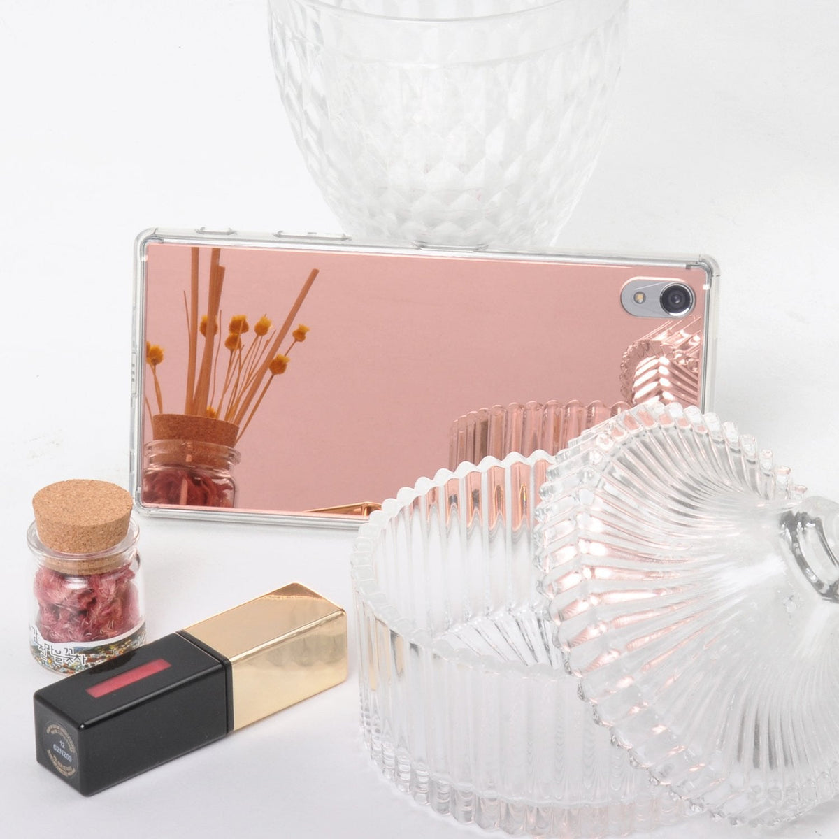 Xperia Z5 Premium Case | Mirror - Rose Gold - Rose gold mirror phone case reflecting dried flowers, beside a glass jar and lipstick.