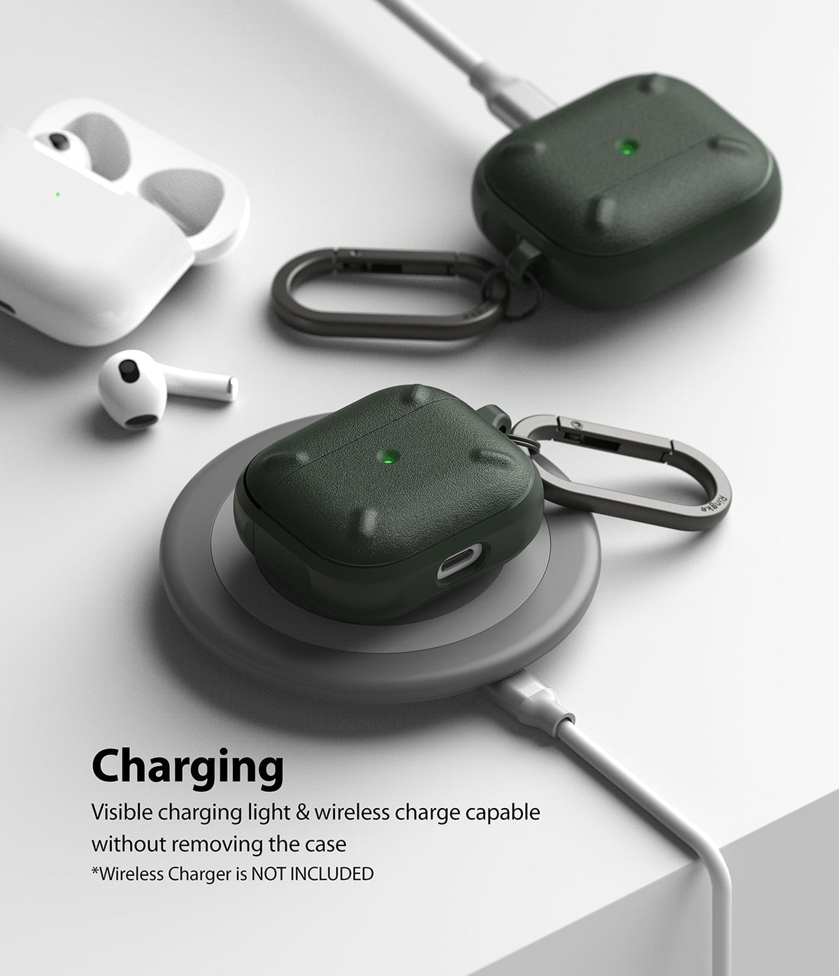 AirPods 3 Case | Onyx - Two dark green textured AirPods 3 cases with carabiners, one charging wirelessly on a pad.
