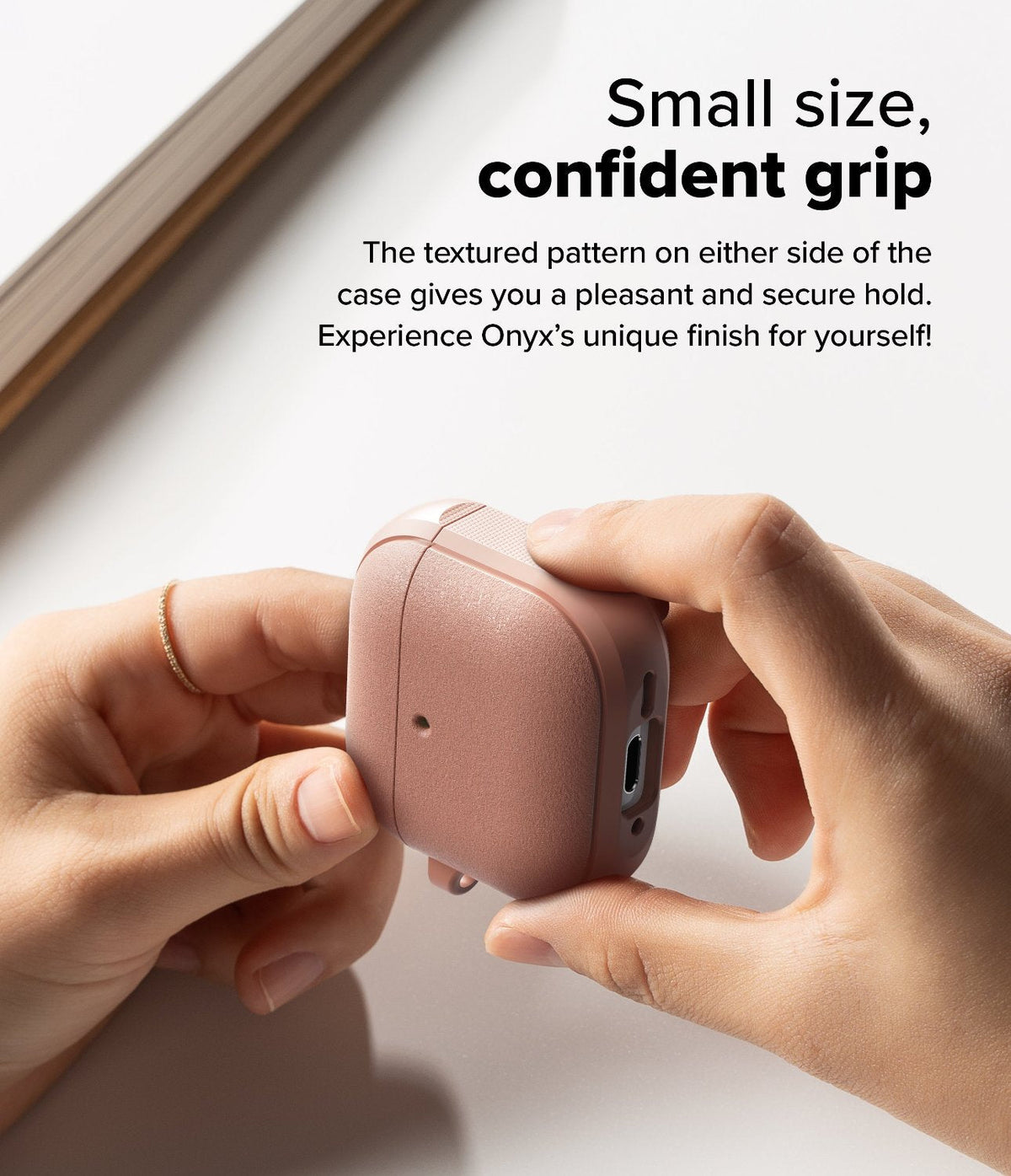 AirPods 5 / 4 Case | Onyx Magnetic - Hands holding a textured, dusty rose AirPods 4 case with side grip detailing.