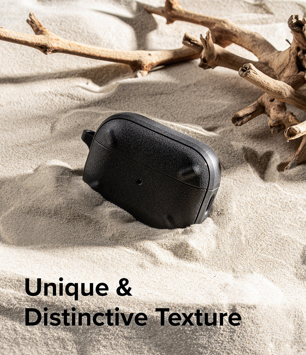 AirPods Pro 2 Case | Onyx - Black textured AirPods Pro 2 case resting on sand next to driftwood with text overlay.