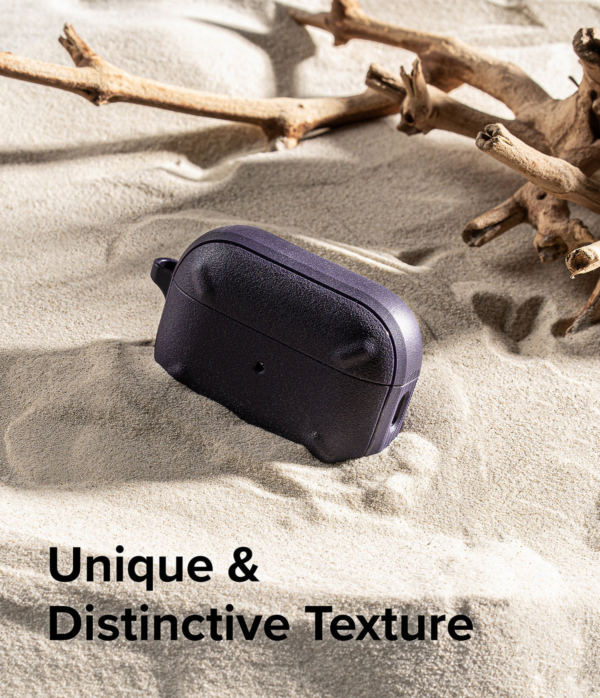 AirPods Pro 2 Case | Onyx - Textured dark purple case resting on sand near driftwood with text overlay.