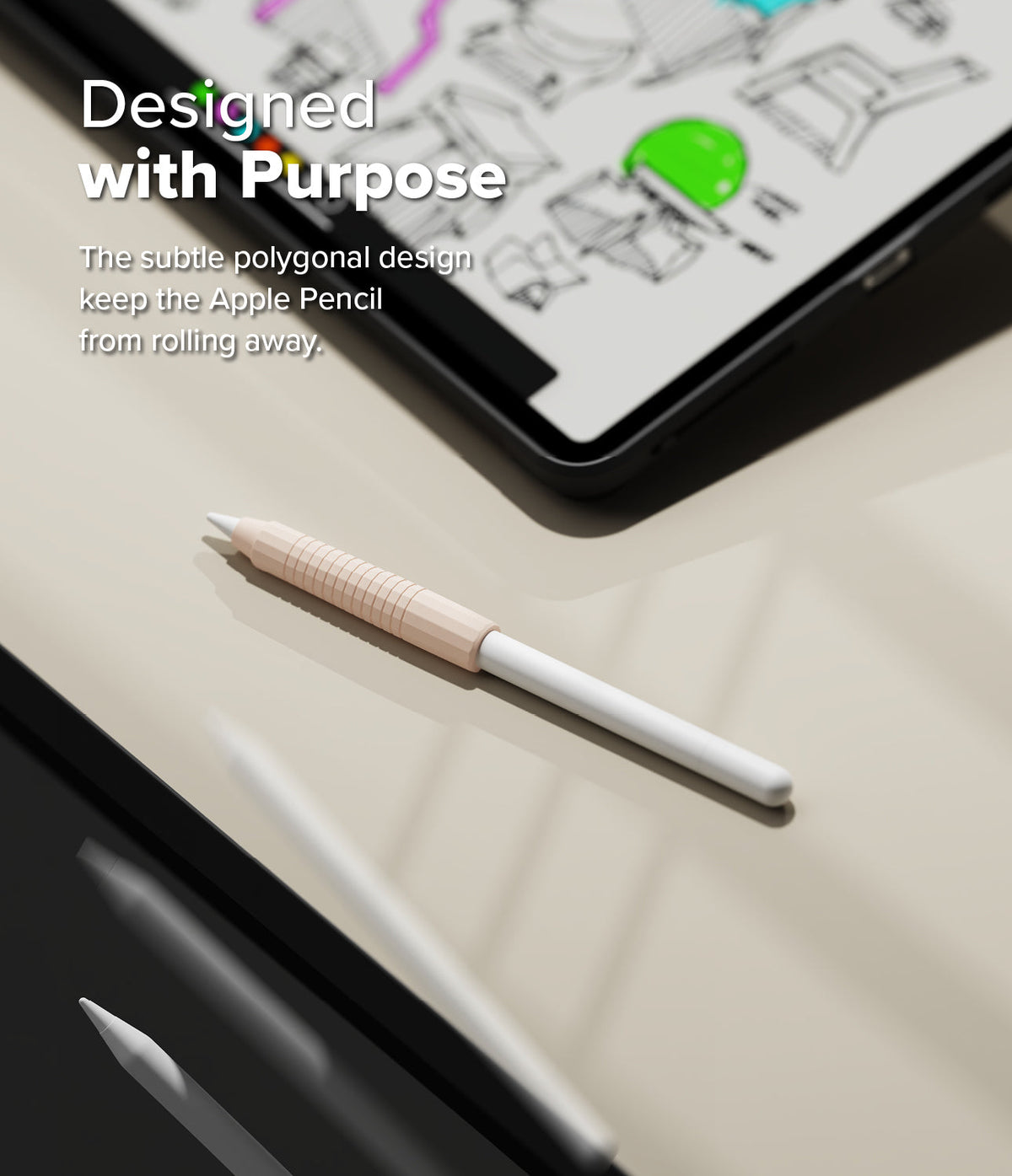 Apple Pencil Case | Silicone Drafting Grip Holder - Apple Pencil Case - A light pink polygonal silicone grip on an Apple Pencil resting on a desk near a tablet.