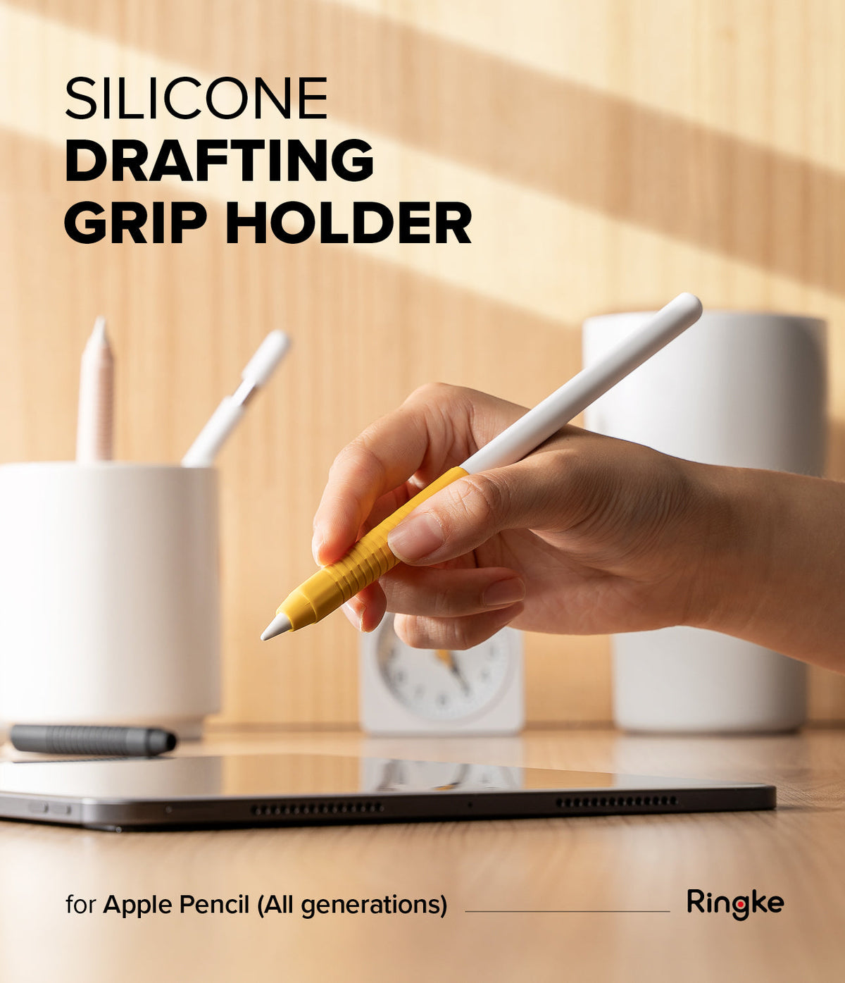 Apple Pencil Case | Silicone Drafting Grip Holder - Apple Pencil Case - Hand holding an Apple Pencil with a yellow silicone drafting grip over a tablet on a wooden desk.