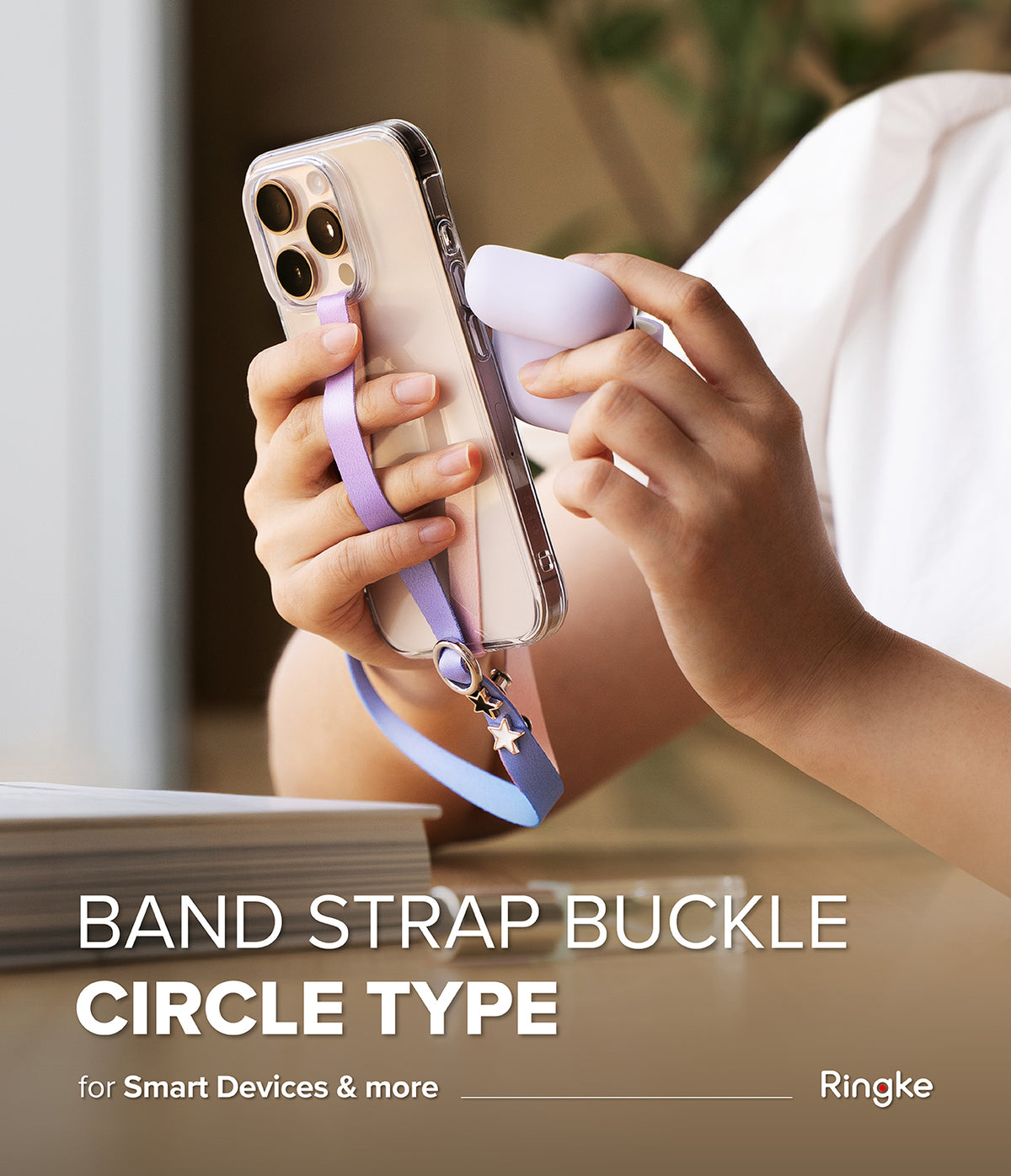 Band Buckle Circle Type Strap - A hand holding a phone with a purple wrist strap featuring a metal circle and star charms.