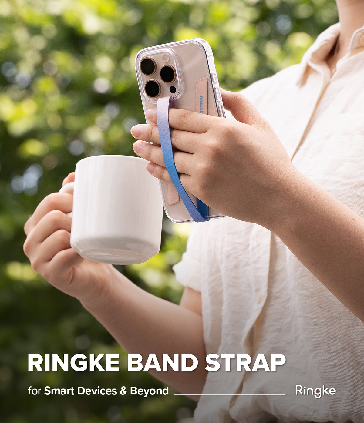 Band Strap - Person holding a white mug and a phone with a colorful gradient finger strap attached to the clear case.