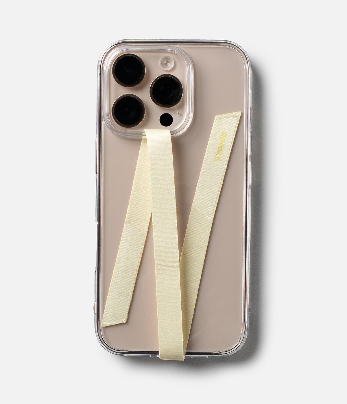 Band Strap - A beige smartphone in a clear case with a pale yellow fabric strap attached in a V-shape pattern.
