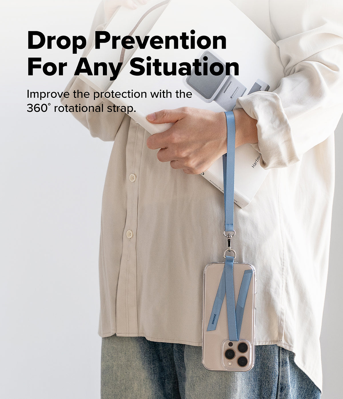 Hand Strap Hook - A person holds a book while a blue phone strap hangs from their wrist, attached to a clear phone case.