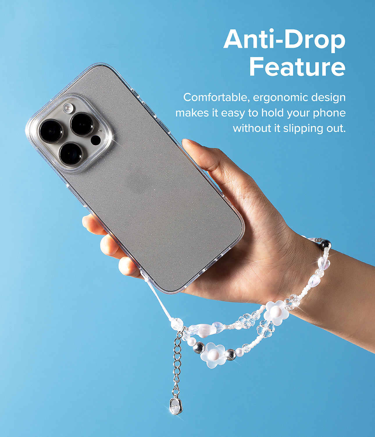 Beaded Strap - Hand holding a glittery phone case with a decorative floral beaded wrist strap against a blue background.