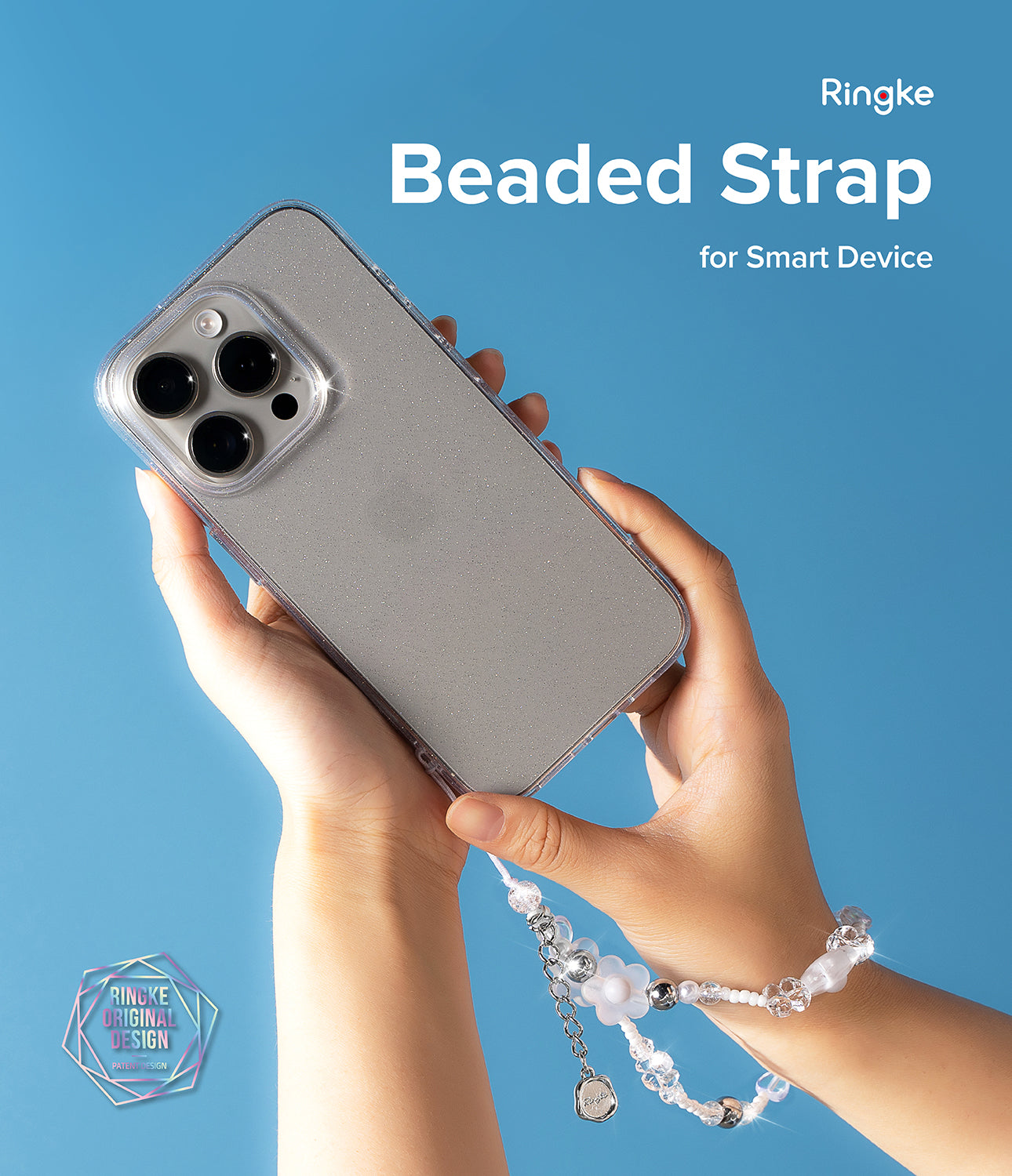 Beaded Strap - Hands holding a glittery smartphone case attached to a decorative beaded wrist strap against a blue background.