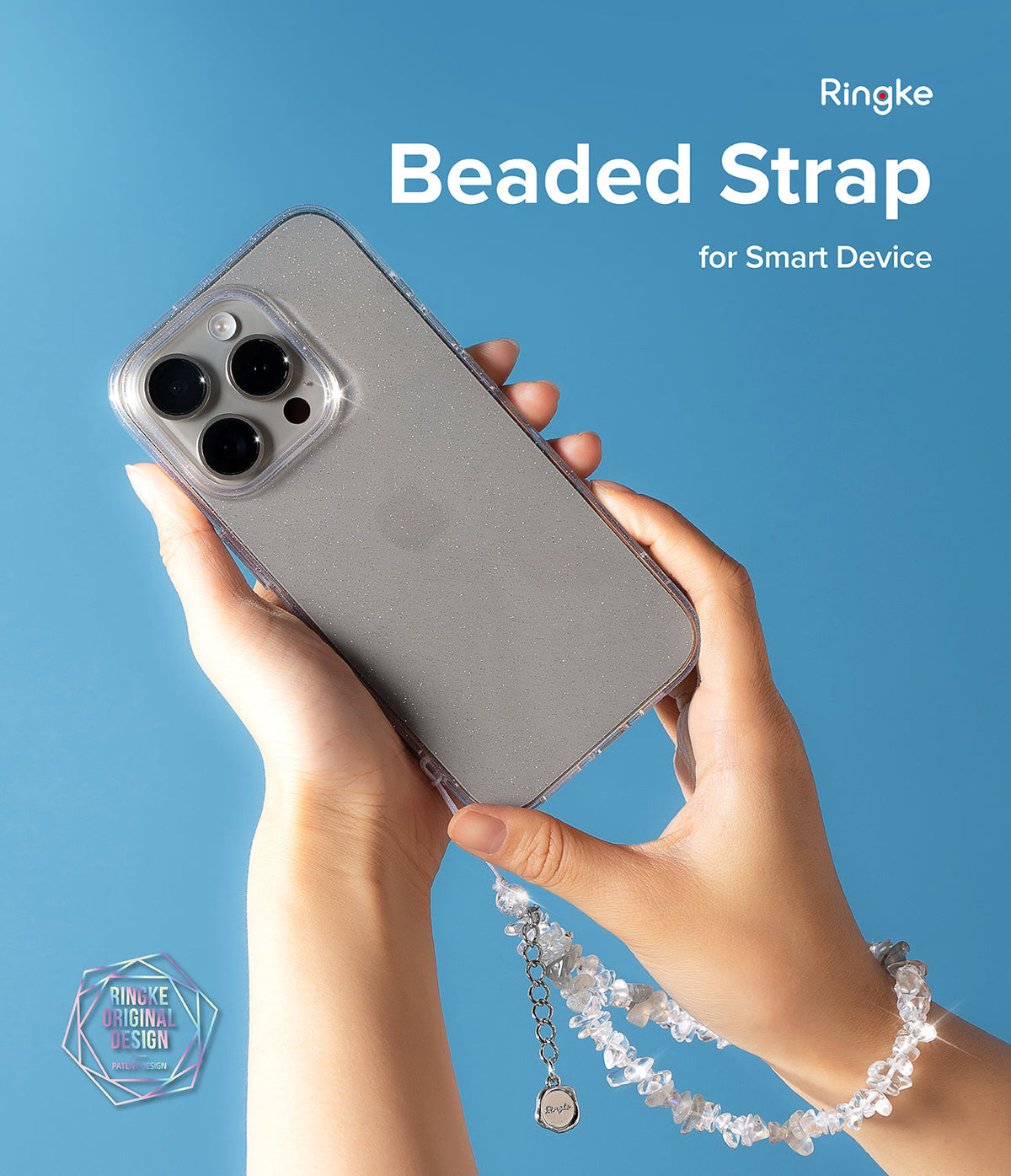 Beaded Strap - Hands holding a glittery phone case with a dangling, sparkling crystal beaded wrist strap on a blue background.