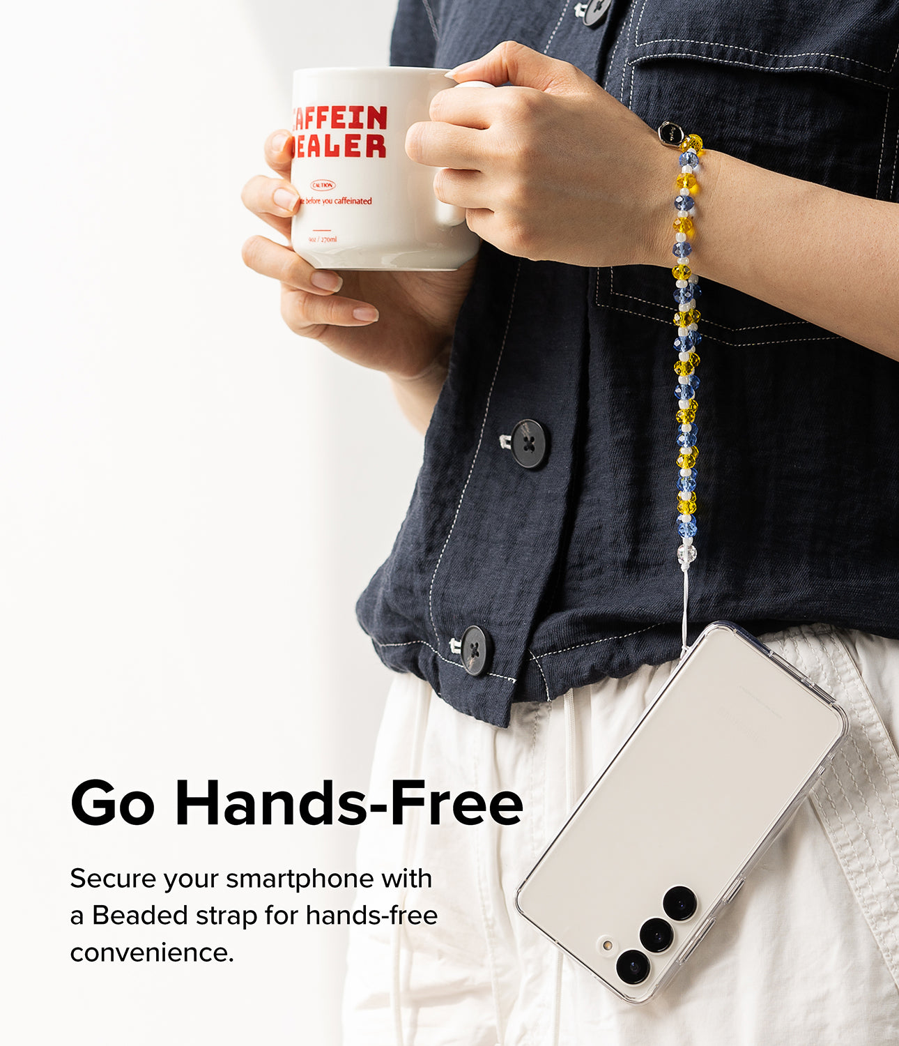 Beaded Strap - Person holding a coffee mug with a blue, yellow, and white beaded phone strap wrapped around their wrist.