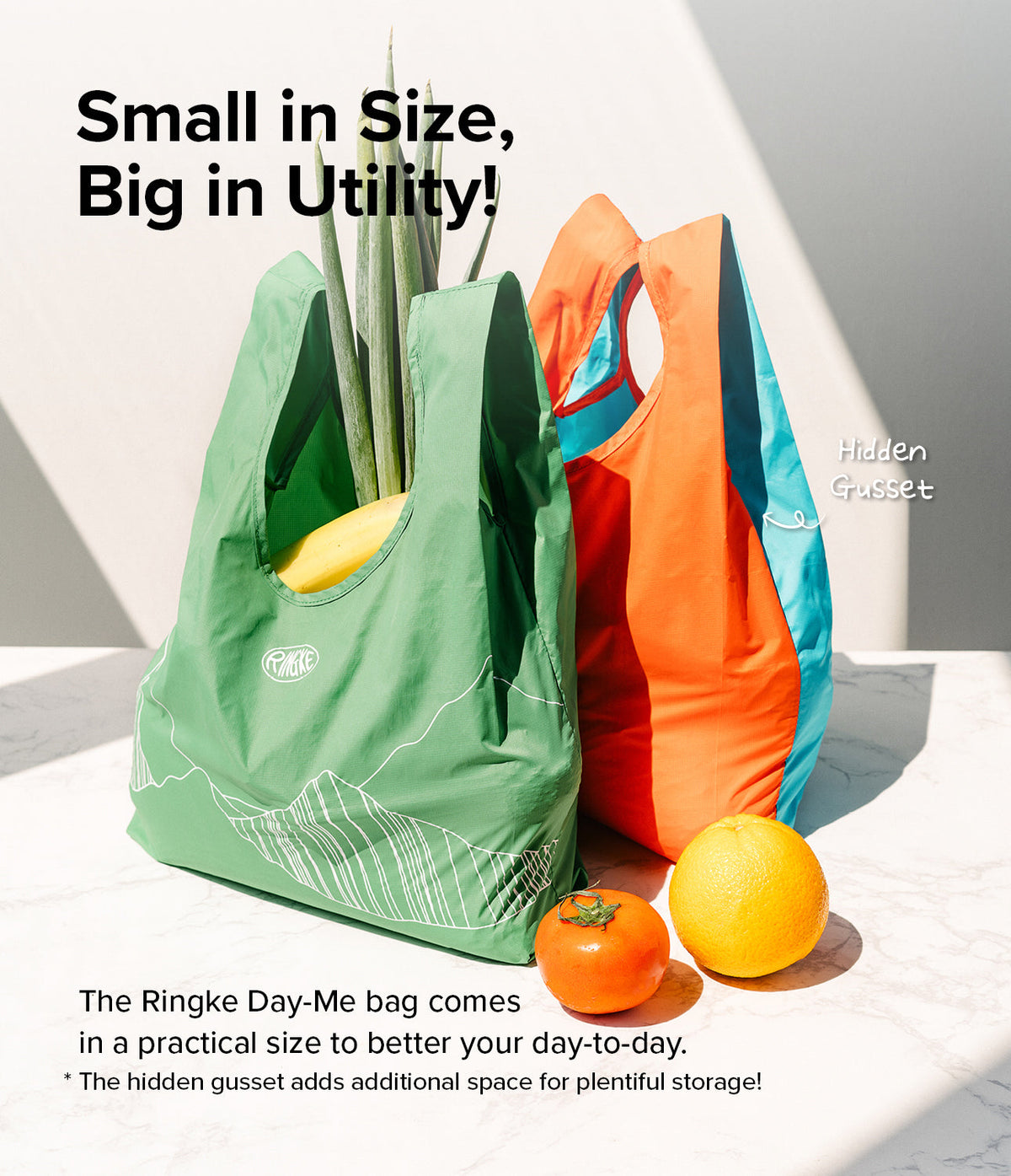 Day-Me Bag - Green and orange reusable shopping bags with hidden gussets, filled with produce on a marble surface.