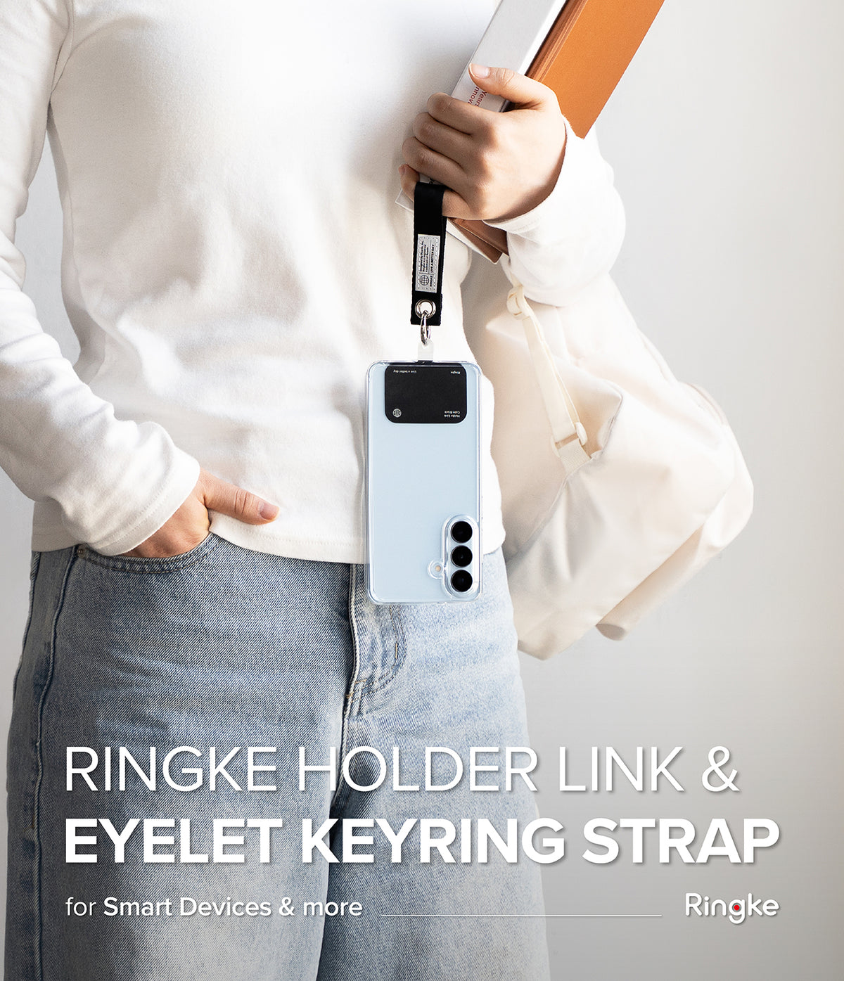 Holder Link Eyelet Keyring - A person holding a phone with a black strap attached to a metal eyelet keyring.