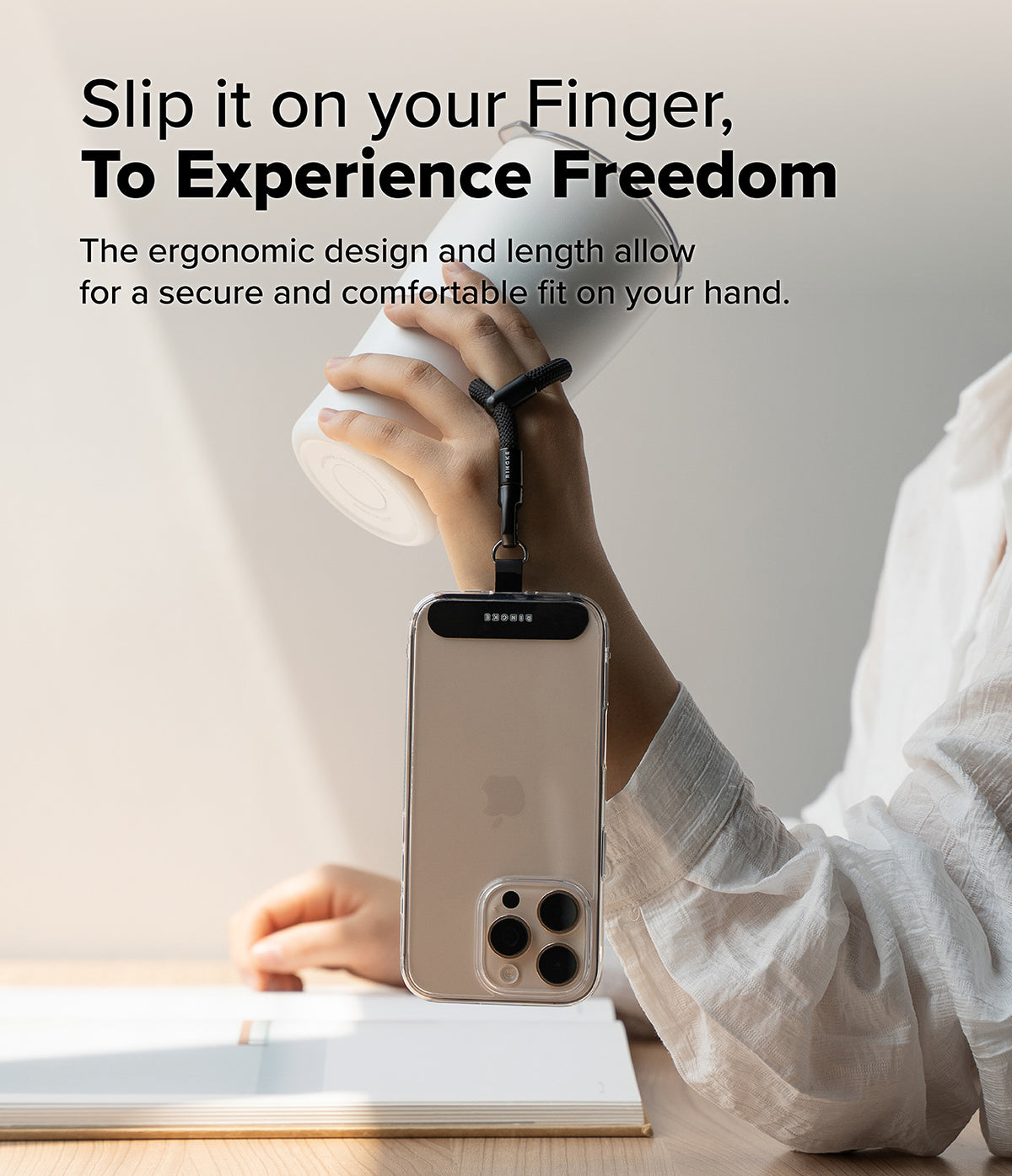 Holder Link Flow Finger Ring - A hand holds a white tumbler while a smartphone hangs securely from a finger via a black strap.