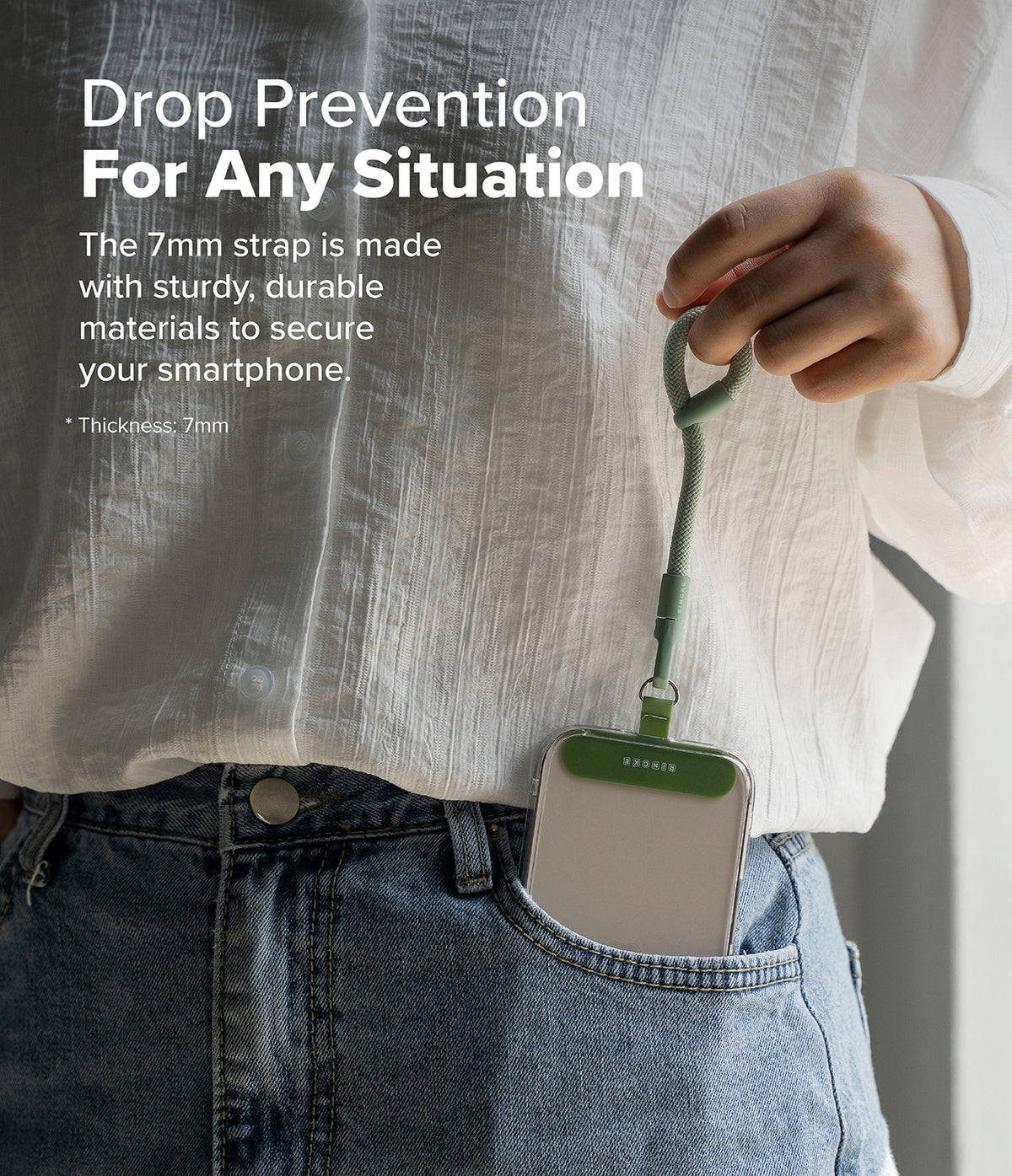 Holder Link Flow Finger Ring - A person holding a green finger strap attached to a smartphone case tucked in a jeans pocket.