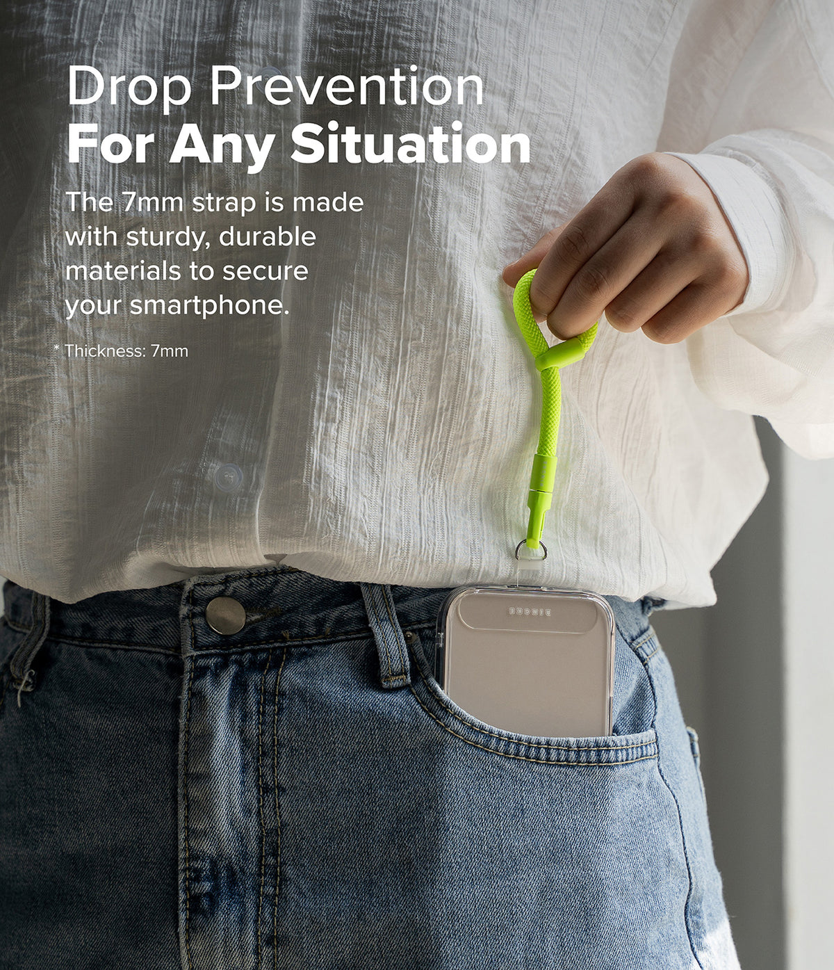 Holder Link Flow Finger Ring - A person holding a bright green smartphone finger strap attached to a phone inside a jeans pocket.