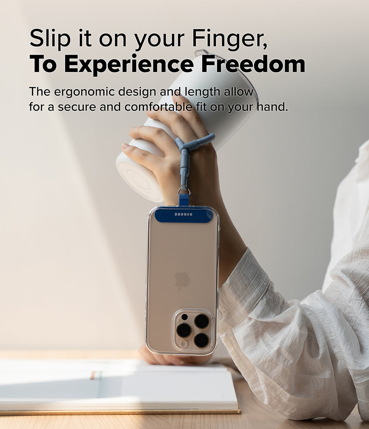 Holder Link Flow Finger Ring - A blue finger strap attached to a smartphone case, held by a hand also gripping a white tumbler.