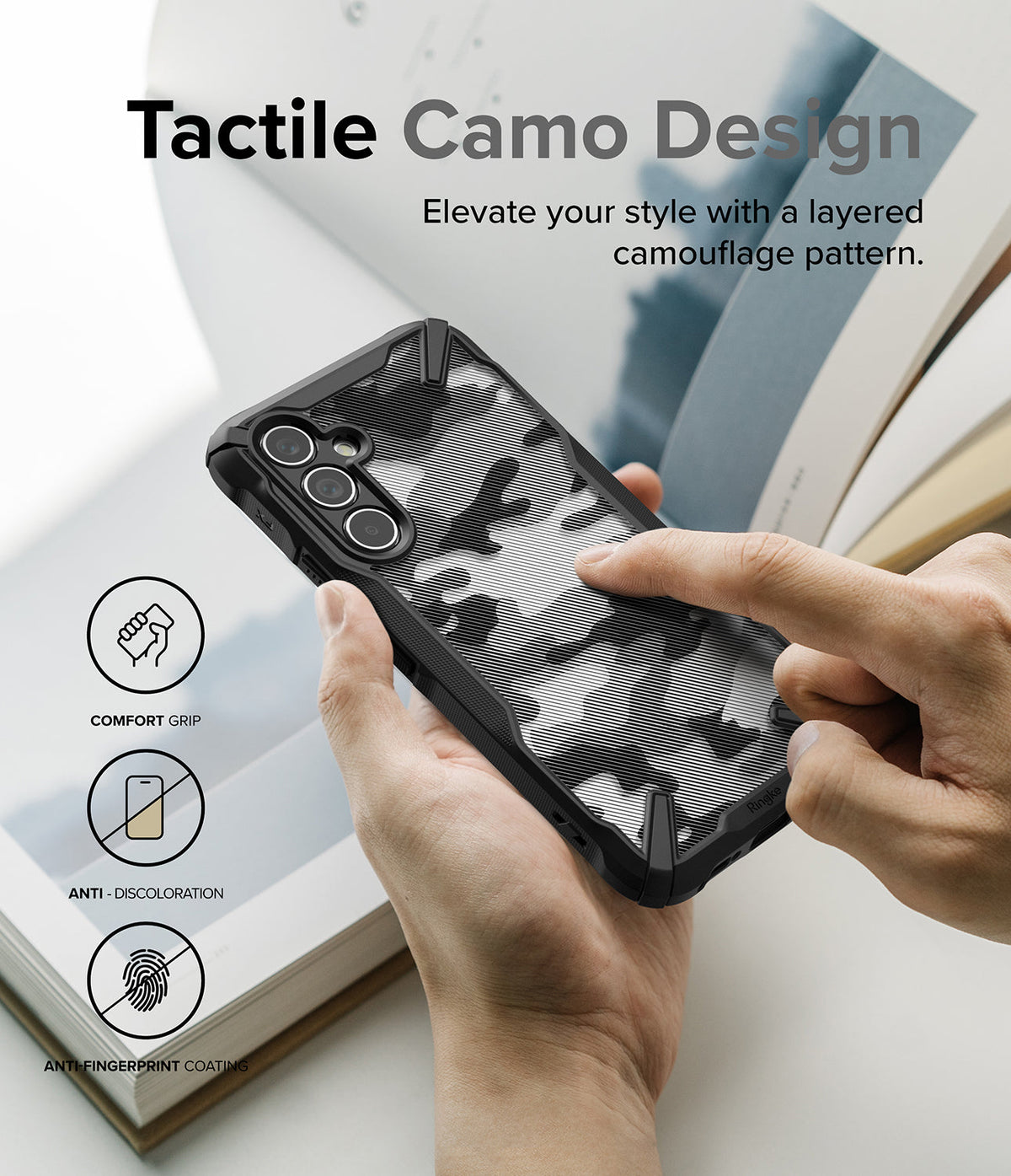 Galaxy A54 Case | Fusion-X - Hands holding a black phone case with a tactile, layered camouflage pattern and feature icons.