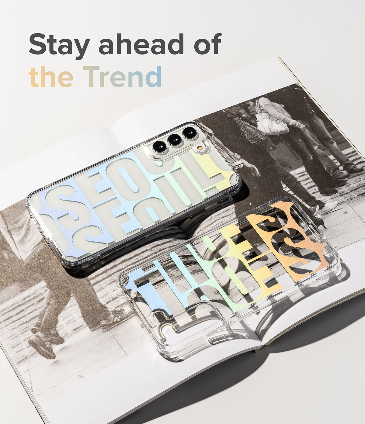 Galaxy S22 Ultra Case | Fusion Design - Two clear phone cases with pastel gradient typography resting on an open magazine.