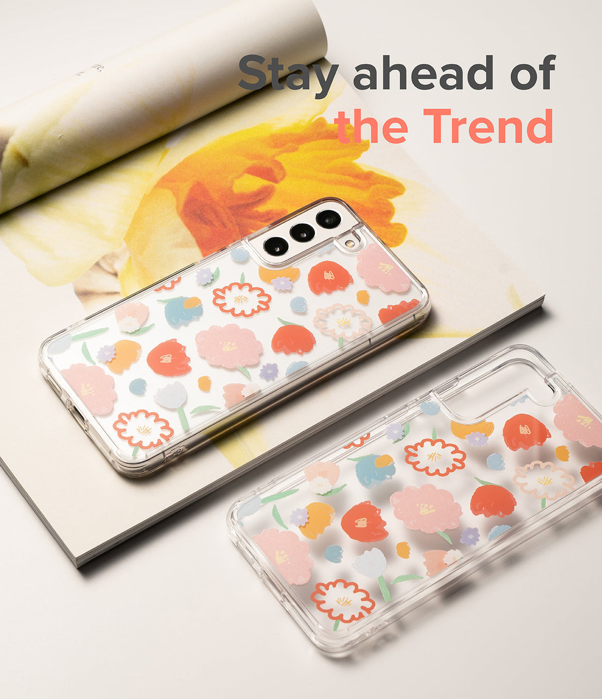 Galaxy S22 Plus Case | Fusion Design - Two clear phone cases with colorful floral patterns resting on a floral magazine.