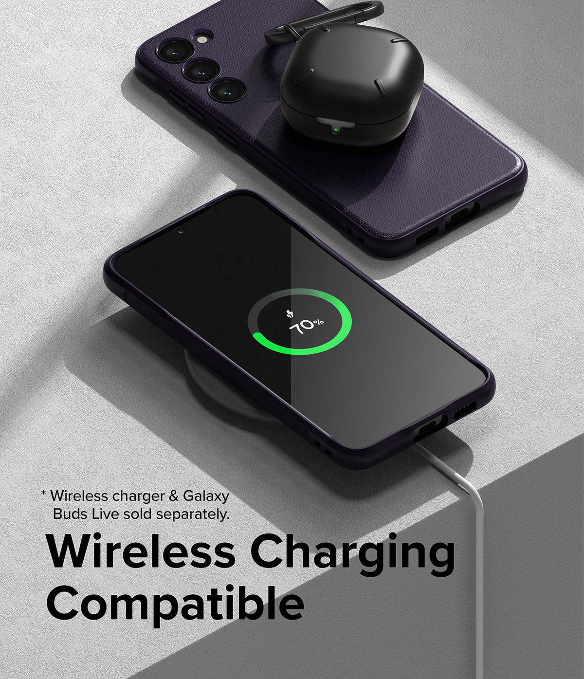 Galaxy S23 Plus Case | Onyx - A phone in an Onyx case wirelessly charging with earbuds resting on a second case.