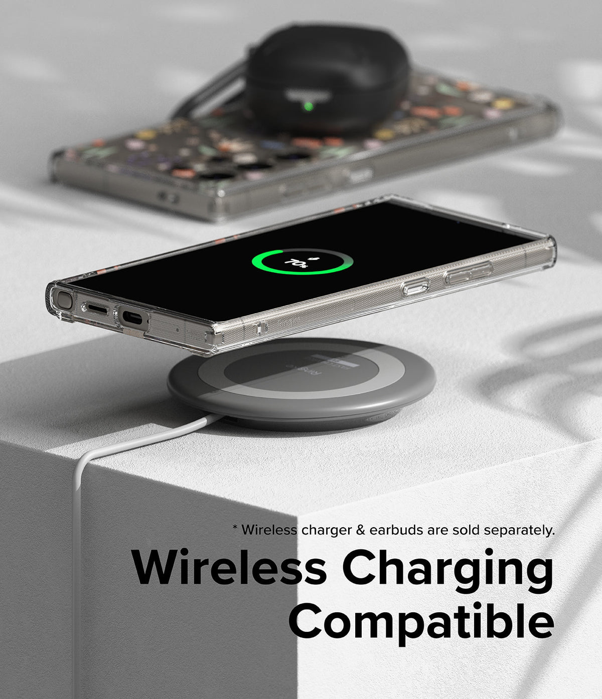 Galaxy S24 Ultra Case | Fusion Design - Phone in clear case wirelessly charging on a pad with earbuds in the background.