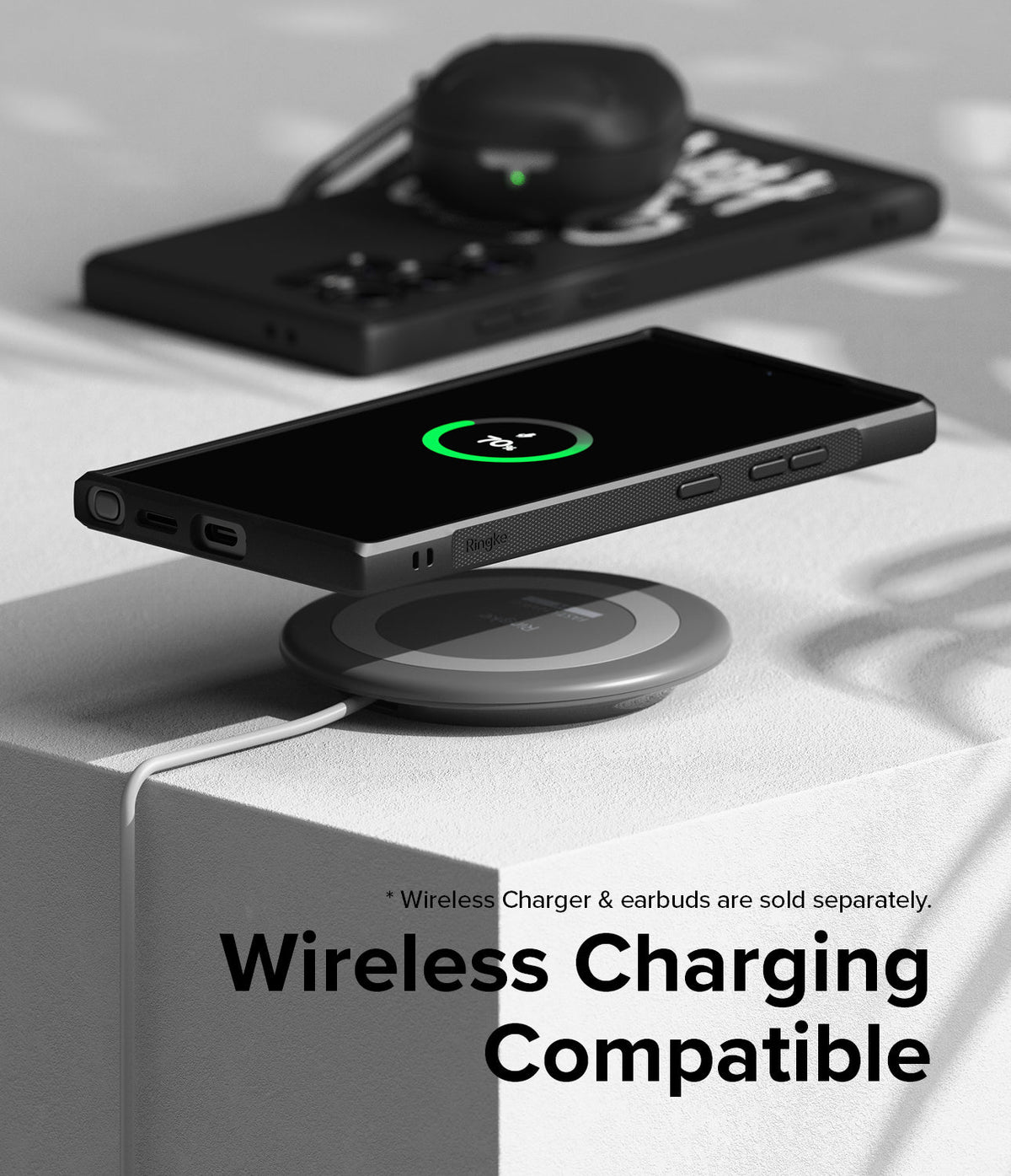 Galaxy S24 Ultra Case | Onyx Design - Black phone in Onyx case wirelessly charging on a pad with earbuds in the background.