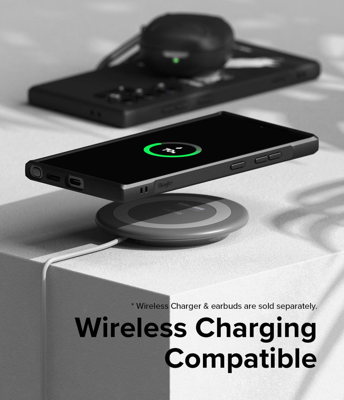 Galaxy S24 Ultra Case | Onyx Design - Smartphone in black case wirelessly charging on a circular pad with earbuds nearby.
