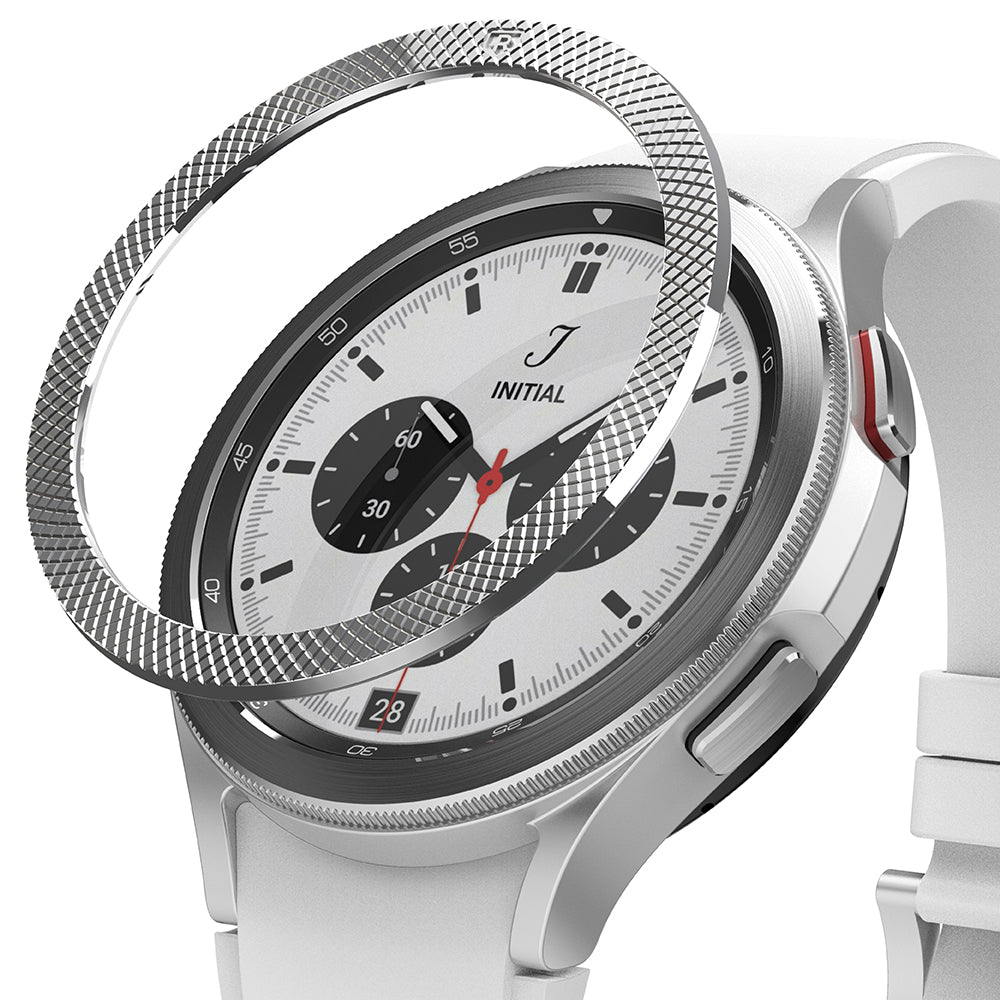 Galaxy Watch 4 Classic 42mm | Bezel Styling - Galaxy Watch 4 Classic 42mm - A textured silver metal bezel ring hovering above a white smartwatch with a chronograph face.