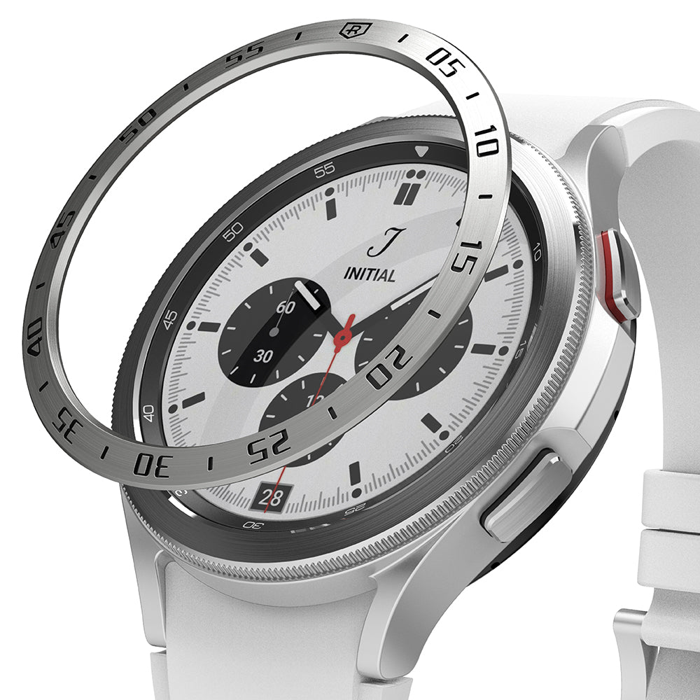 Galaxy Watch 4 Classic 46mm | Bezel Styling - A metallic bezel ring hovering above a silver smartwatch with a white band.