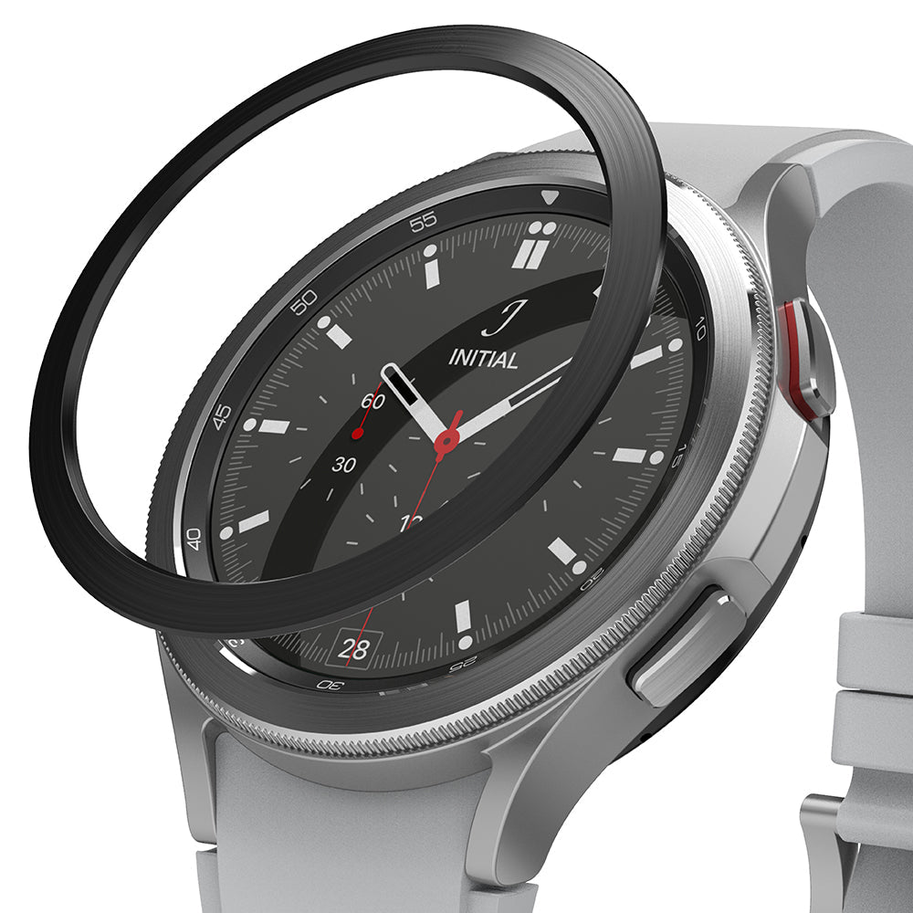 Galaxy Watch 4 Classic 46mm | Bezel Styling - A black adhesive bezel ring hovering above a silver Galaxy Watch 4.