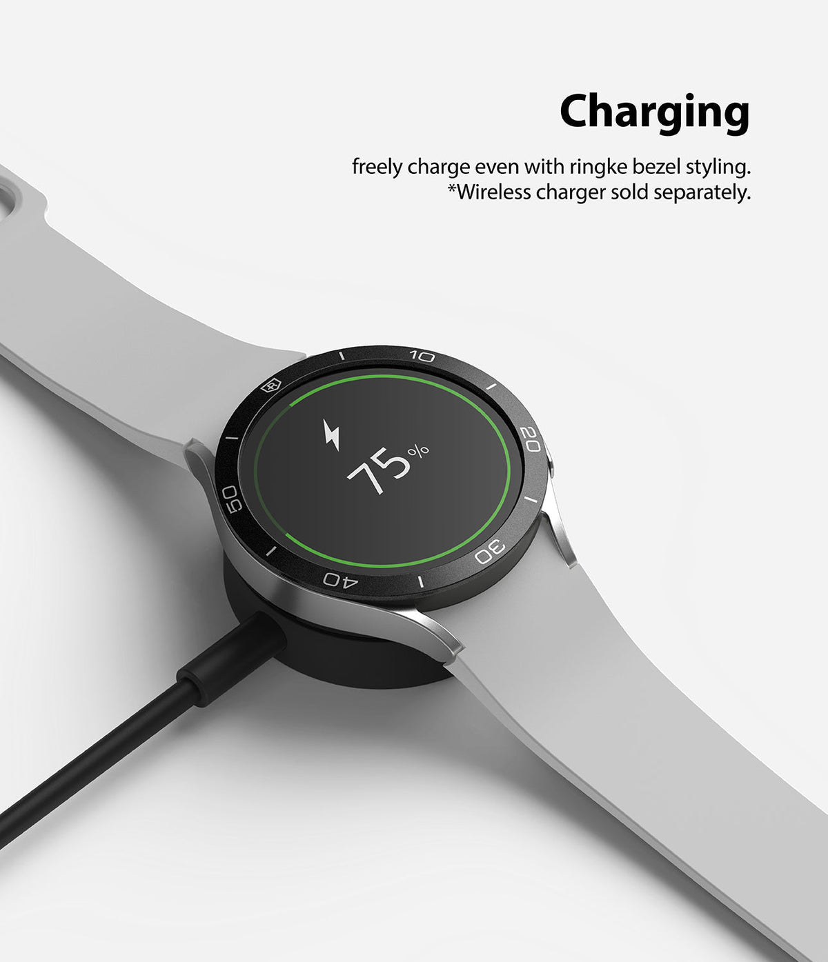 Galaxy Watch 5/4 44mm | Bezel Styling - A smartwatch with a black bezel ring charging wirelessly at 75% battery.