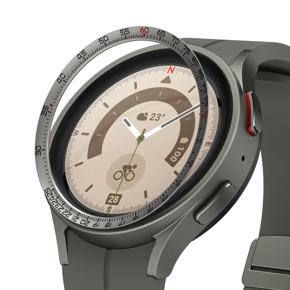 Galaxy Watch 5 Pro 45mm | Inner Bezel Styling - Galaxy Watch 5 Pro 45mm - A metallic bezel ring with tachymeter markings hovering above a grey smartwatch face.