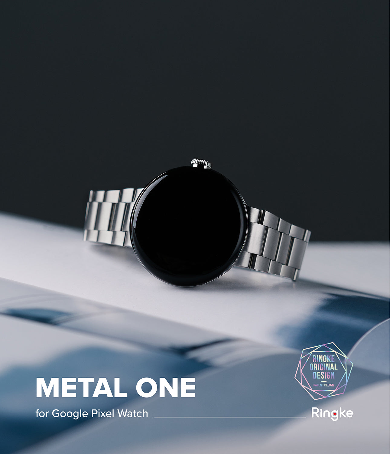 Google Pixel Watch | Metal One Band - Silver metal link watch band attached to a black Google Pixel Watch on a white surface.