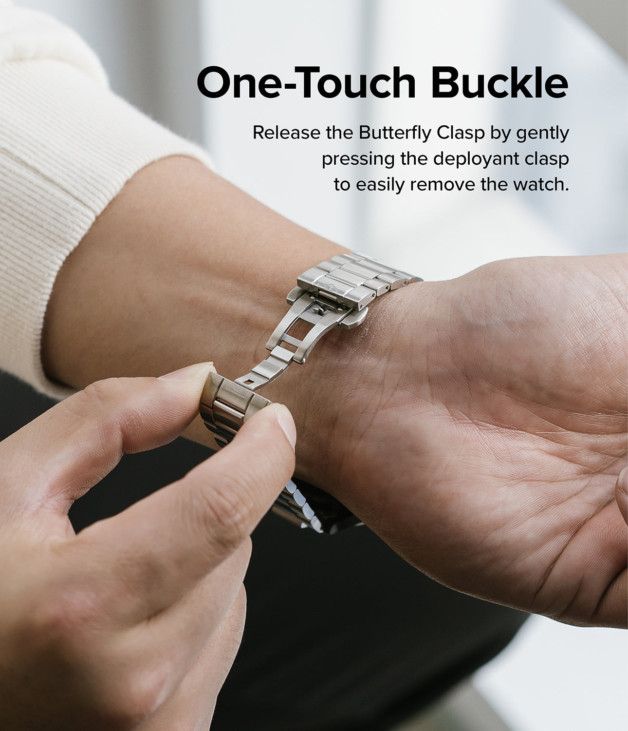 Google Pixel Watch | Metal One Band - Hands opening the butterfly clasp of a silver metal watch band on a wrist.