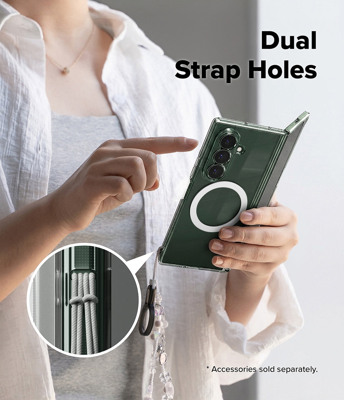 Galaxy Z Fold 8 Ultra Case | Fusion Magnetic - A person holds a dark green smartphone case with a circular MagSafe ring and a hanging cord, pointing to the back of the case. The image includes text reading 'Dual Strap Holes' and a circular inset showing the cord attachment detail.