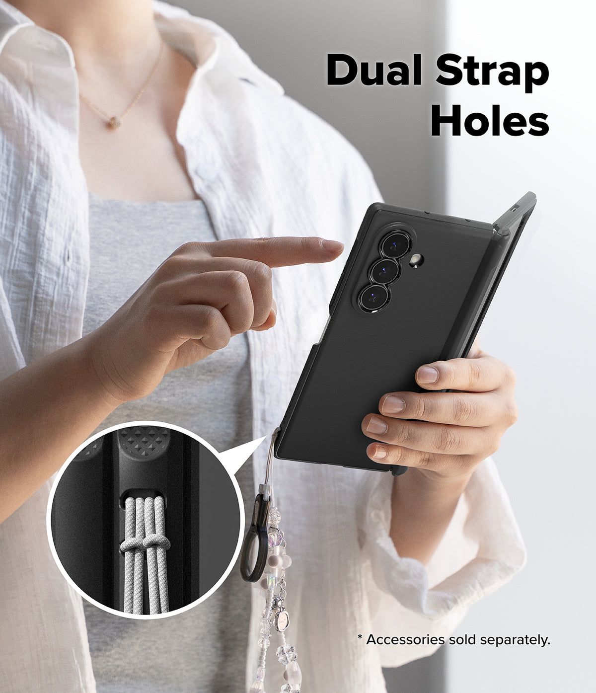 Galaxy Z Fold 8 Ultra Case | Onyx Flap - A person holds a black smartphone case with a dangling strap in one hand while pointing to a circular inset showing the dual strap hole detail. Large text reads 'Dual Strap Holes' and small text says accessories are sold separately.