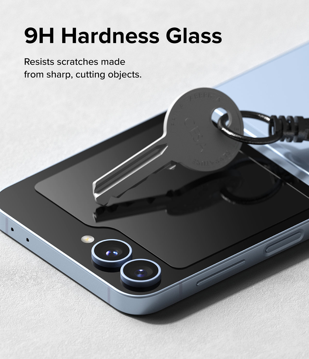Galaxy Z Flip 7 FE Screen Protector | Cover Display Glass (2 Pack) - A metal key resting on a phone cover display to demonstrate 9H scratch resistance.