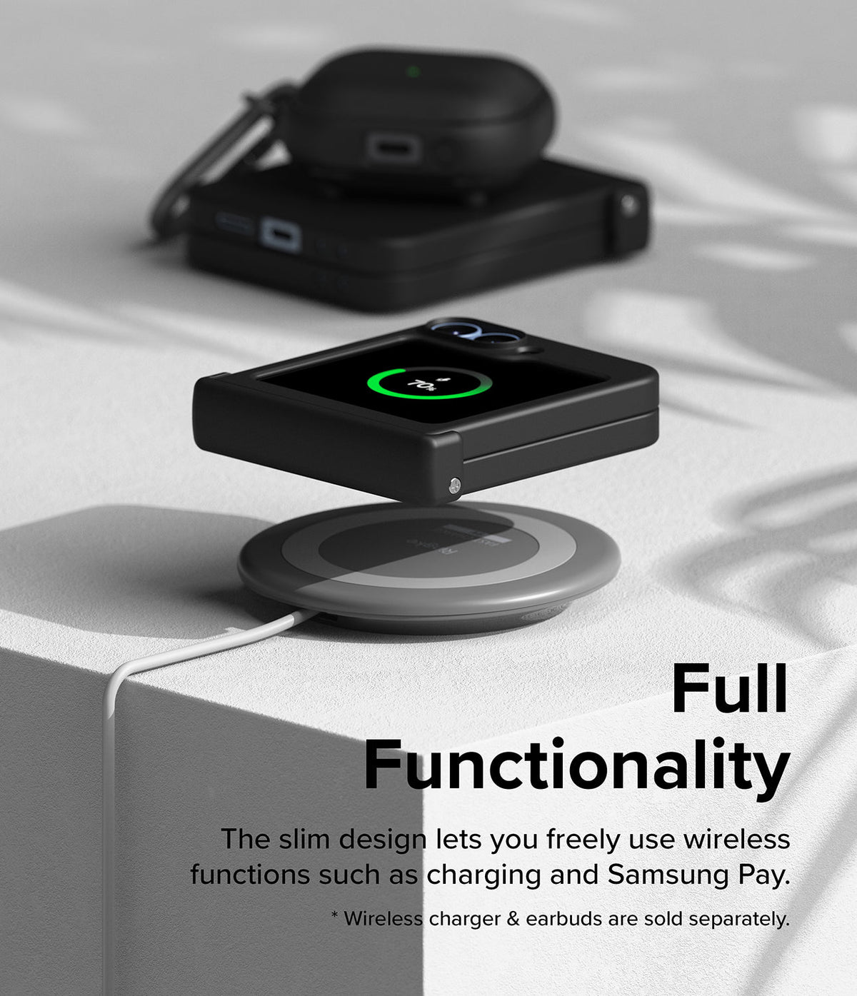 Galaxy Z Flip 7 FE Case | Slim Hinge - Folded phone in a black case wirelessly charging on a pad with earbuds nearby.
