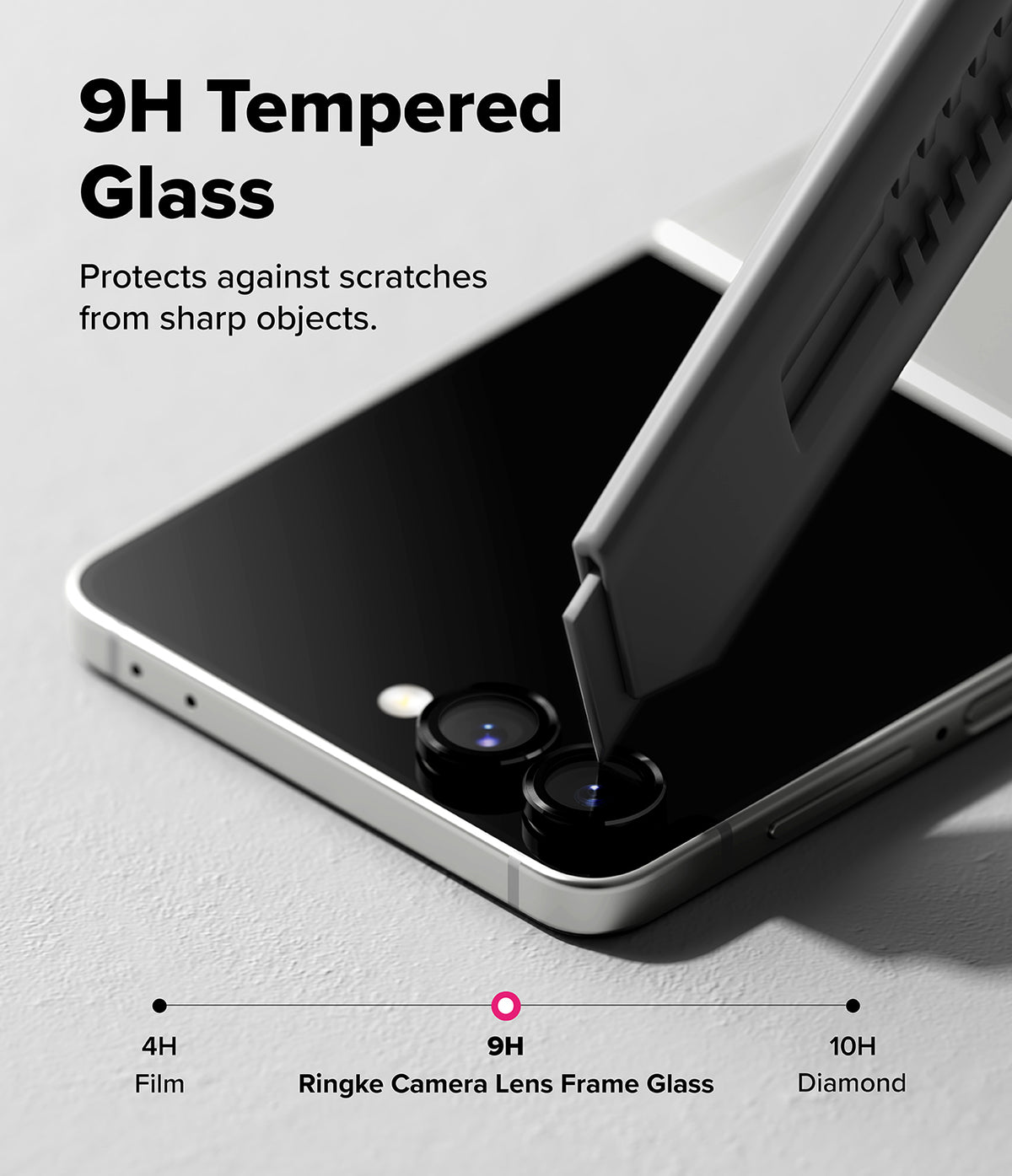 Galaxy Z Flip 7 | Camera Lens Frame Glass (2 Pack) - A utility knife blade presses against the 9H tempered glass camera lens protector on a smartphone.