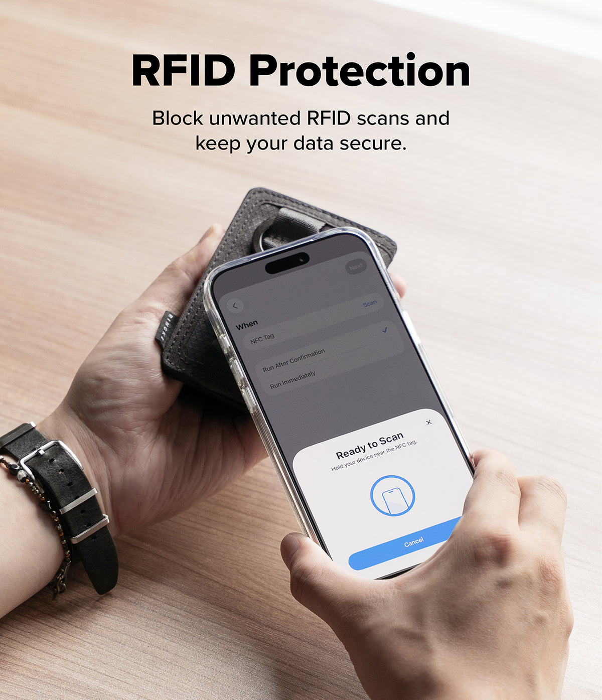 Wallet | Tech Magnetic - A person holds a smartphone over a dark gray RFID-blocking case on a light wood surface, with text reading 'RFID Protection' and a phone app screen visible.