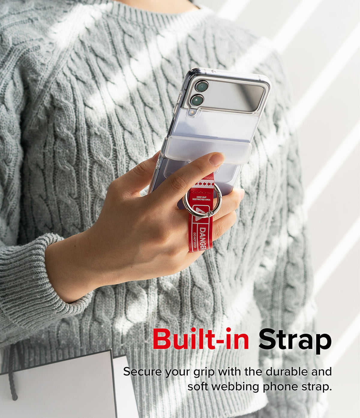 Galaxy Z Flip 7 FE / 6 / 5 / 4 / 3 | Hinge Cover Tarpaulin - Hand holding a phone with a red Danger-themed strap.