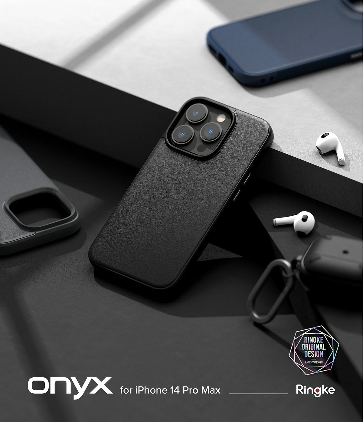 iPhone 14 Pro Max Case | Onyx - Textured black phone case on a desk with wireless earbuds and a blue phone case.