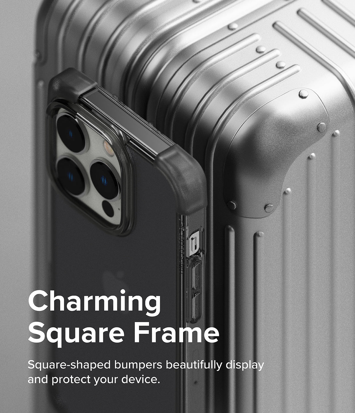 iPhone 14 Pro Case | Fusion Bumper - A black square-frame phone case resting against a metallic silver suitcase.