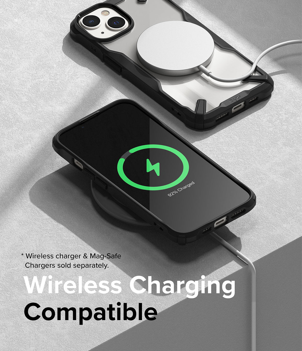 iPhone 14 Case | Fusion-X - iPhone 14 in a black Fusion-X case charging wirelessly with a MagSafe puck and a charging pad.